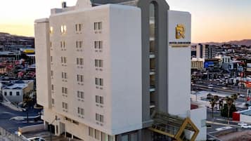 A modern hotel with a prominent 'R' logo, multiple floors, and a central staircase.