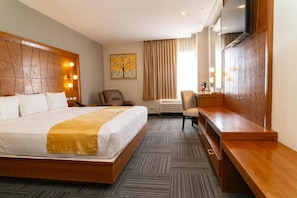 A hotel room with a large bed, a desk, a chair, a television, and a painting on the wall. - Hotel Don Ruben Business & Suites (Chihuahua)