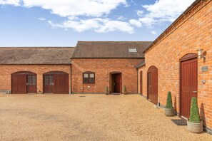 A brick building with multiple large doors and a gravel courtyard. - 3 Bed in Yoxall (oc-s46074) (Hadley End)