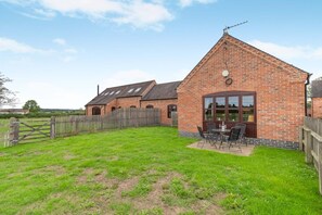 A brick building with a patio area and a wooden fence. - 2 Bed in Yoxall (oc-s46075) (Hadley End)