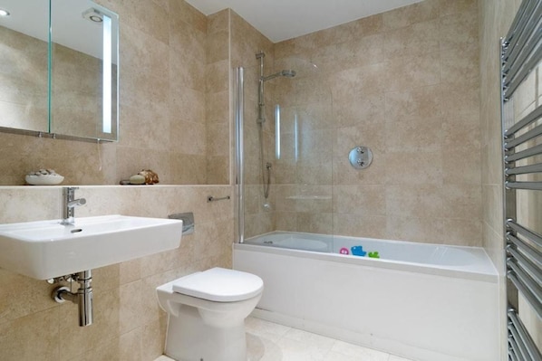 A bathroom with a glass-enclosed shower, a white sink, and a toilet. - 3 Bed in Porth (oc-b584338) (Newquay)