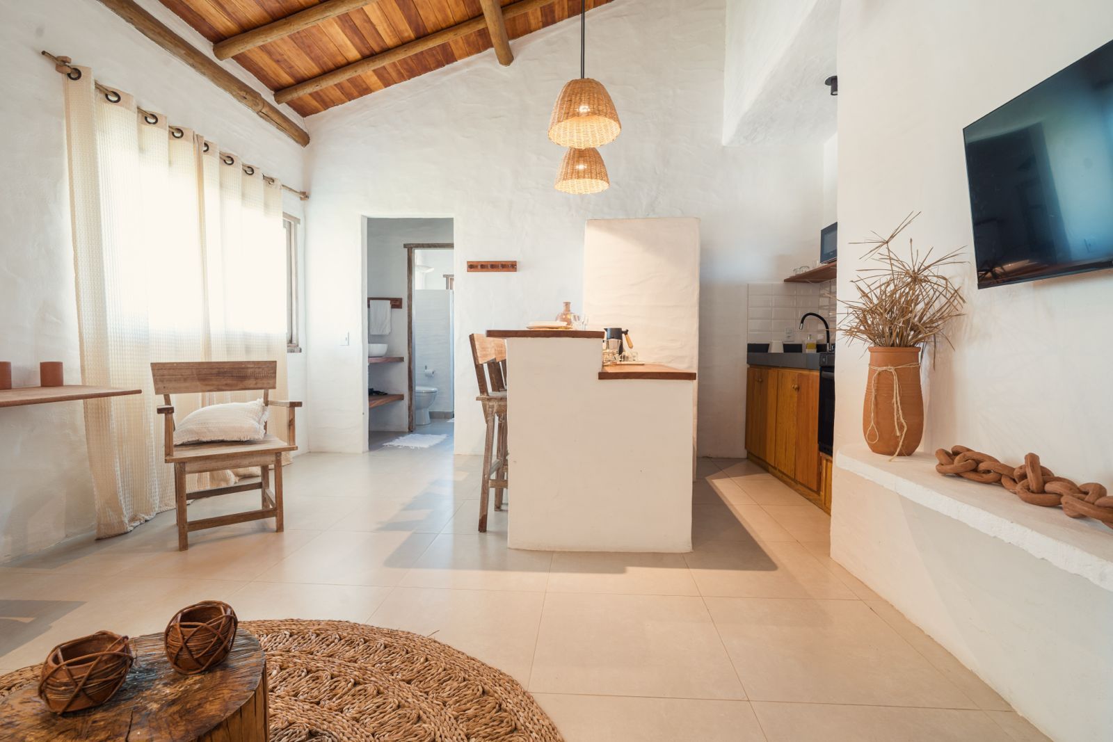 A modern kitchen with a central island, wooden furniture, and a large window.