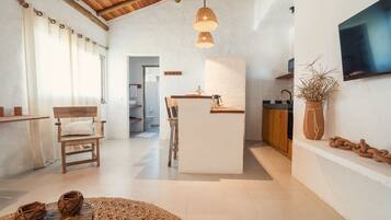 A modern kitchen with a central island, wooden furniture, and a large window.