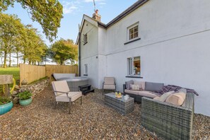 A patio area with a hot tub, seating, and a small table with drinks. - 1 Bed in Talgarreg (oc-t46321) (Talgarreg)