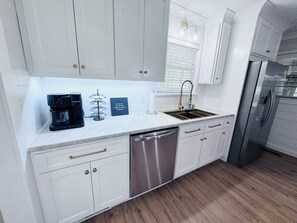 A modern kitchen with white cabinetry, stainless steel appliances, and a built-in dishwasher. - The Parkway House: A peaceful 3-bedroom house on top of Lookout Mountain (Fort Payne)
