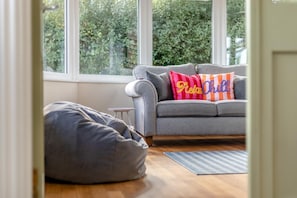 A room with a grey sofa, a bean bag chair, and a small table. There are two pillows with text on them. - 5 Bed in Newbridge-on-Wye (oc-u46325) (Newbridge on Wye)