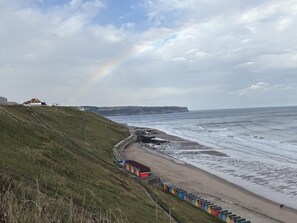 A coastal landscape with a beach, a train track, and a rainbow. - 2 Bed in Whitby (oc-s46340) (Whitby)
