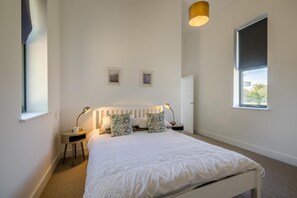 A bedroom with a bed, bedside lamps, a window, and a door. - 3 Bed in Roughton (oc-e46003) (Roughton)