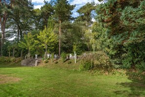 A well-maintained garden with a stone wall, seating area, and various trees. - 3 Bed in Penpedairheol (oc-o46341) (Penpedairheol)