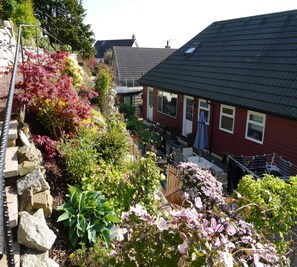 A residential area with houses, a garden with various plants, and a metal structure. - 4 Bed in Kirkcudbright (oc-d546533) (Kirkcudbright)