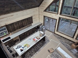 A modern kitchen with a large island, dark wooden cabinets, and large windows offering views of the outdoors. - Brand New !! - Coming between Nov 23rd - Dec 1st, 2026. Check back soon!! (Smithville)