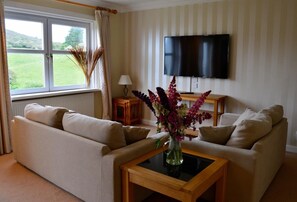 A living room with two sofas, a coffee table, a TV, and a window with curtains. - 3 Bed in Dalbeattie (oc-d582562) (Portling)
