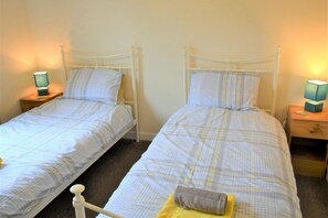 A twin room with two single beds, each with a nightstand and a lamp. - 2 Bed in Dalbeattie (oc-d546078) (Dalbeattie)