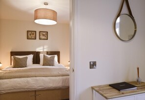 A bedroom with a bed, a bedside table with a book and a candle holder, a hanging lamp, and two wall-mounted pictures. - 2 Bed in New Galloway (oc-d550751) (New Galloway)