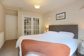 A hotel room with a bed, a bedside lamp, a door, and a wall-mounted picture. - 2 Bed in Creetown, Newton Stewart (oc-d586440) (Creetown)