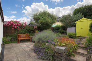 A garden with a bench, a yellow shed, and a variety of plants. - 2 Bed in Creetown, Newton Stewart (oc-d586440) (Creetown)