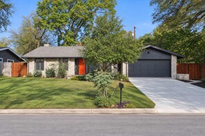 Enjoy a quiet tree lined street with a spacious front yard and driveway, easy parking for the whole group. - Southbound Social | Pool • Patio • Games & Movies (Austin)