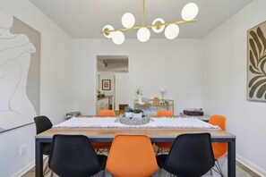 Gather for meals under a statement chandelier at this stylish table, with bold accent chairs seating the whole group comfortably. - Southbound Social | Pool • Patio • Games & Movies (Austin)