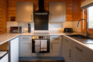 Eine kleine Küche mit Backofen, Mikrowelle, Toaster und Spüle.