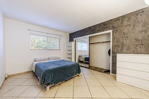 A bedroom with a bed, a wardrobe, a mirror, and a window with blinds. - Amazing Berryman # 8 (Los Angeles)