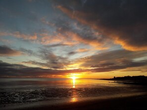 Ein Sonnenuntergang über einem Gewässer mit Wolken am Himmel.