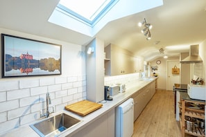 A modern kitchen with a skylight, a wooden cutting board, and a dishwasher. - 8 Bed in New Galloway (oc-d594998) (New Galloway)