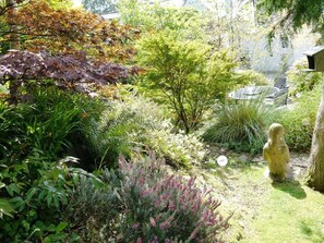 Un jardín con diversas plantas y una estatua.