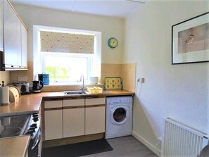 A compact kitchen with a washing machine, a toaster, and a sink. - 2 Bed in Sandyhills (oc-d546307) (Southwick)