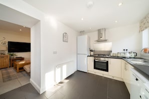 Una cocina moderna con horno empotrado, estufa y refrigerador.