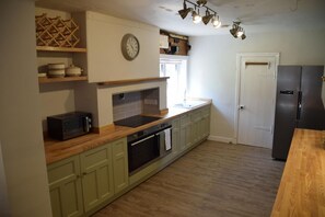 A kitchen with wooden cabinets, a built-in oven, a microwave, a sink, and a refrigerator. - 4 Bed in Rockcliffe (oc-d585839) (Rockcliffe)