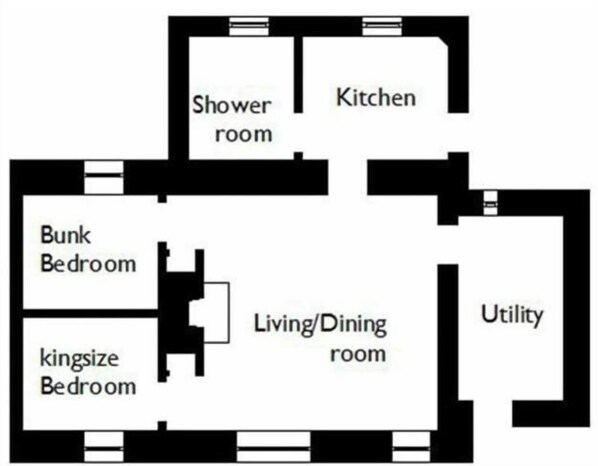 Un plano de planta que muestra una cocina, sala de estar/comedor, dos dormitorios y un área de servicios.