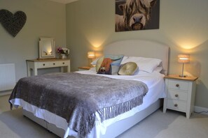 Ein Schlafzimmer mit einem Bett, Nachttischen, einem Spiegel und einem Wandbild.