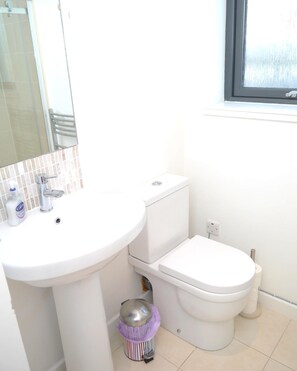 A bathroom with a white sink, toilet, and a window. - 4 Bed in Castle Douglas (oc-d637110) (Rhonehouse)