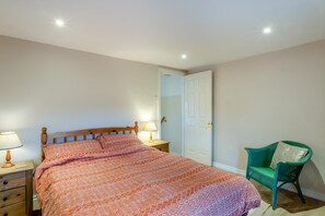 A bedroom with a bed, two bedside tables, a chair, and a door. - 2 Bed in Grafham (oc-w45994) (Grafham)