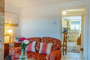 A cozy living room with a sofa, a lamp, and a vase of flowers. - 2 Bed in Grafham (oc-w45994) (Grafham)