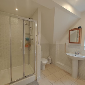 A bathroom with a glass-enclosed shower, a toilet, a sink, and a mirror. - 4 Bed in Southgate (oc-n46057) (Southgate)