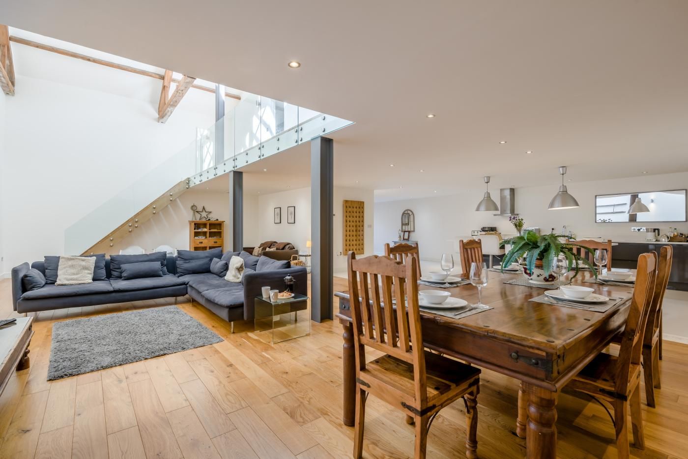 A modern living space with a dining area, a staircase, and a kitchen.