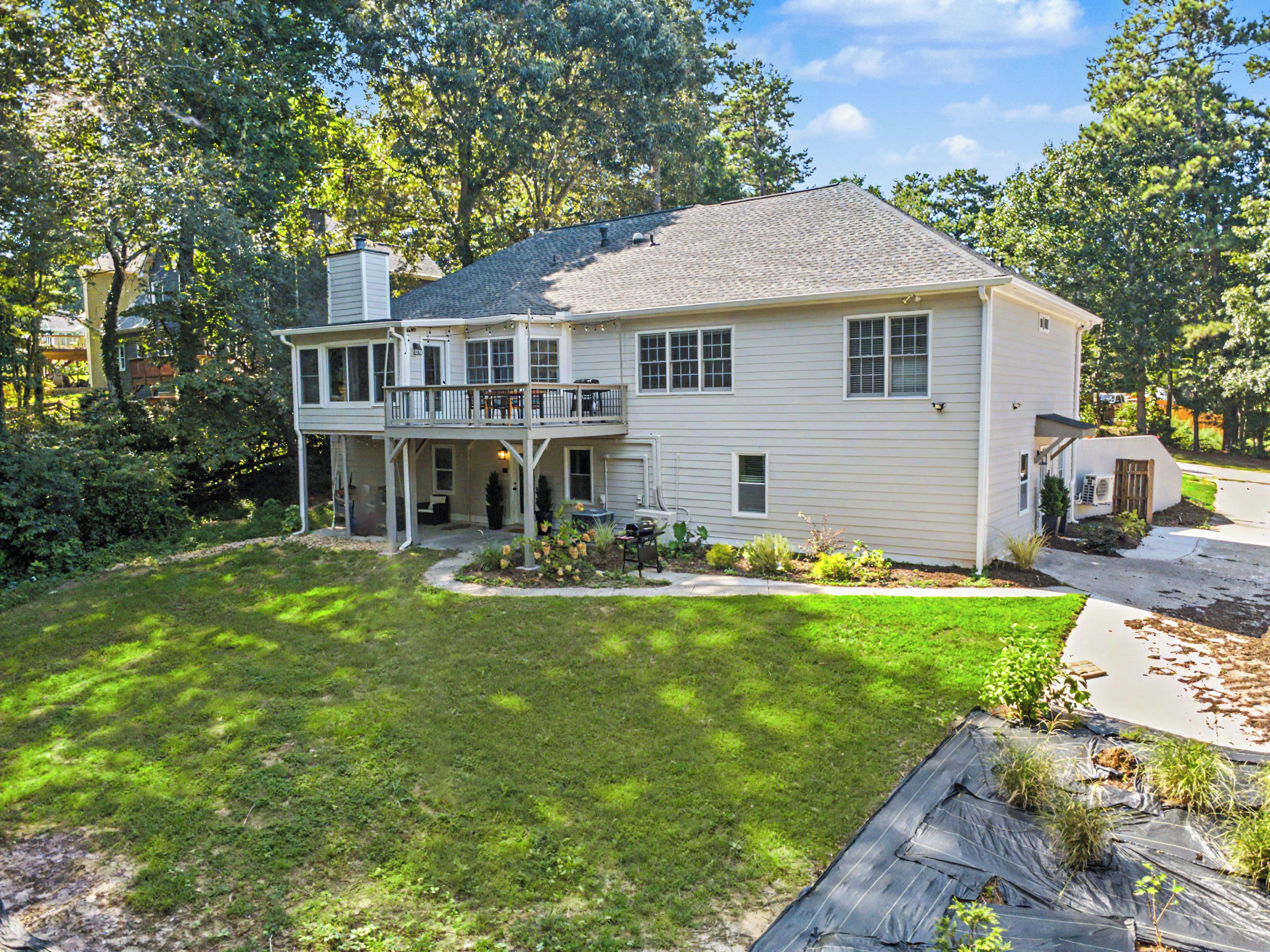 A two-story house with a covered porch and a fenced yard.