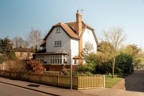 A two-story house with a white facade, a brown roof, and a brick chimney. - 4 Bed in Beccles (oc-v46416) (Beccles)