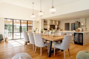 A modern kitchen with a dining area, large windows, and a built-in refrigerator. - 4 Bed in Beccles (oc-v46416) (Beccles)