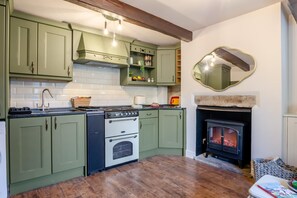 A kitchen with green cabinets, a stove, and a fireplace. - 1 Bed in Haworth (oc-b46415) (Haworth)