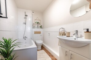 A modern bathroom with a bathtub, toilet, and sink. - 1 Bed in Haworth (oc-b46415) (Haworth)