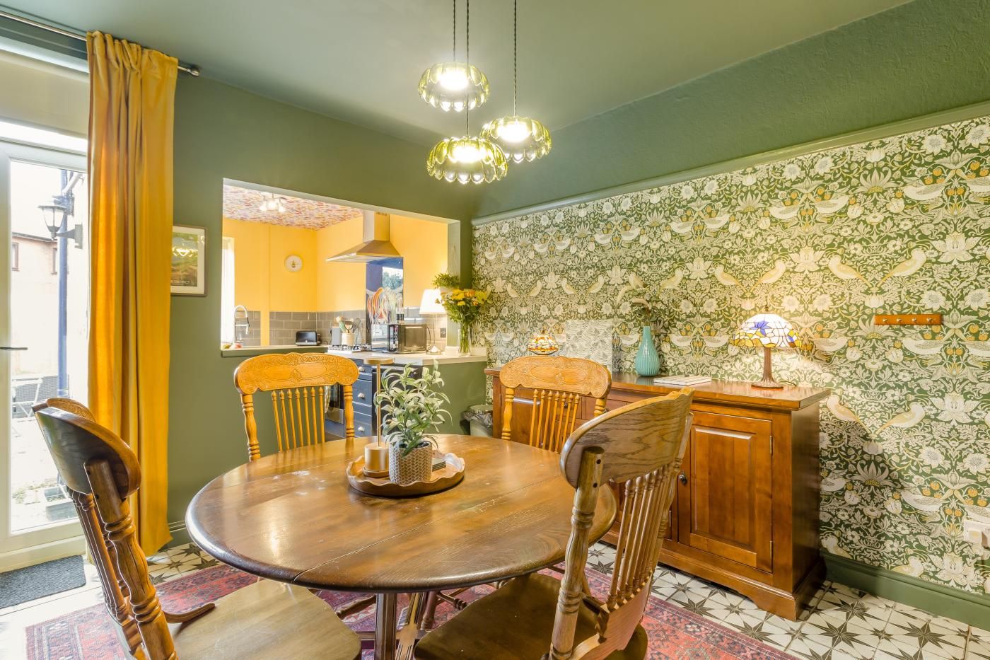 A dining area with a round wooden table, four chairs, and a cabinet.