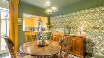 A dining area with a round wooden table, four chairs, and a cabinet.