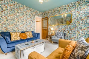 A living room with a blue sofa, a coffee table, and a patterned wallpaper. - 2 Bed in Chesterfield (oc-p46335) (Calow)