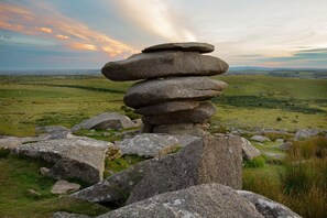 A stone cairn on a grassy hill with a panoramic view of the landscape. - 3 Bed in Callington (oc-t46349) (Harrowbarrow)