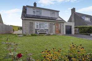 Ein zweistöckiges Haus mit Vorgarten, Holztür und Garage.