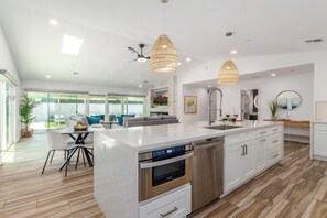 A modern kitchen with a central island, stainless steel appliances, and pendant lighting. - Oldtown Escape (Scottsdale)