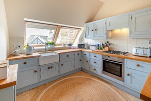 A kitchen with a window, wooden countertop, cabinets, a sink, a stove, and a microwave. - 3 Bed in Fowey (oc-h46394) (Fowey)