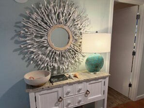 A bathroom vanity with a mirror, a bowl, a book, and a lamp. - Relaxing Oceanview Beach Retreat in Ocean Creek (Myrtle Beach)